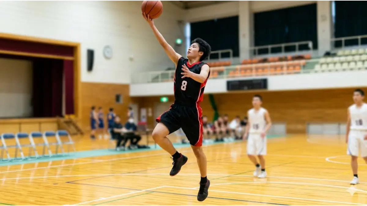 バスケ部の中学生男女が体育館で垂直跳びの平均データを確認する様子