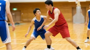 バスケットボールの試合で正しい姿勢で合法的なスクリーンをセットする日本人高校生。